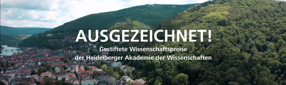 Titelbild des Ausgezeichnet-Film, Heidelberger Altstadt aus der Vogelperspektive, links die Stadt, rechts der Königstuhl. Im Vordergrund über dem Bild in weißer Schrift "AUSGEZEICHNET!" darunter kleiner "Gestiftete Wissenschaftspreise der Heidelberger Akademie der Wissenschaften"